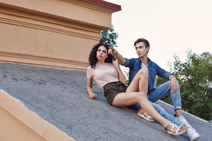 The teenagers sitting on the roof