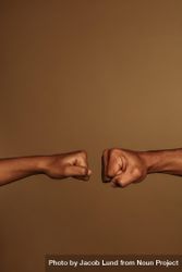 Cropped shot of two fists  isolated on brown background bElYn4