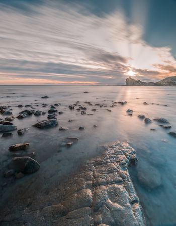 Sundown sky over sea and stony coast