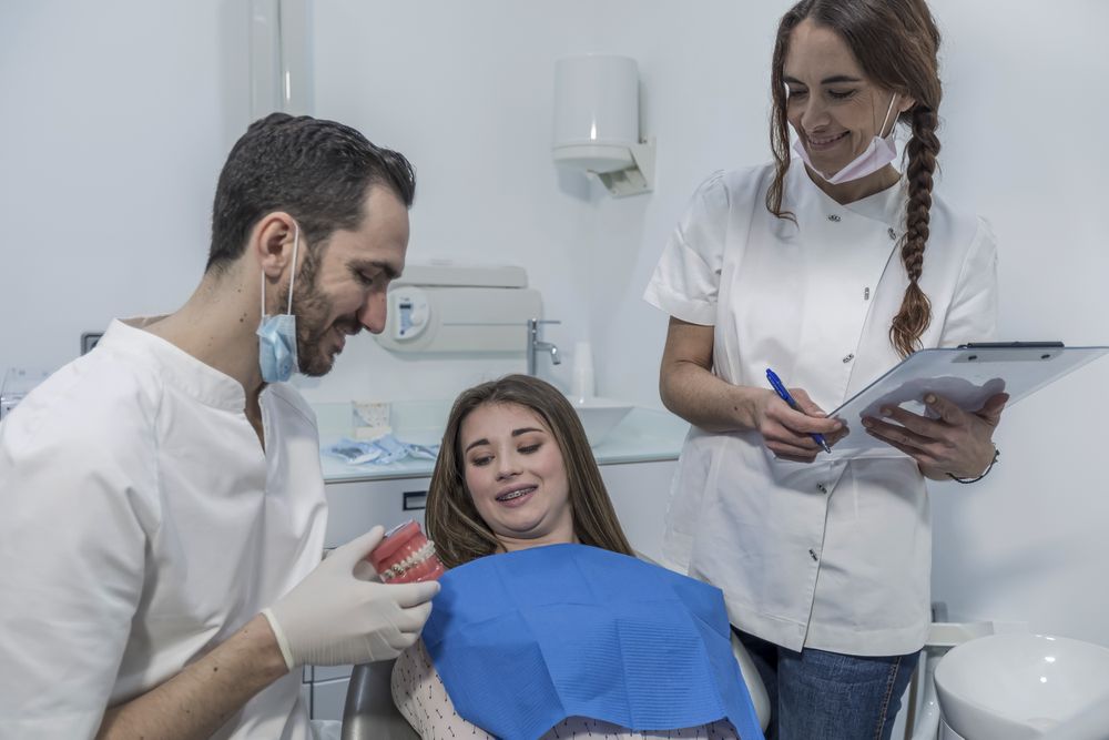 Male dentist show jaw to little girl