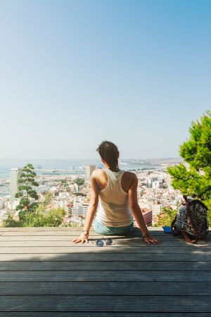 Woman on bench looking at city views from above