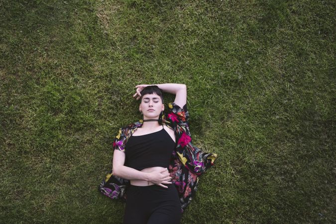 Woman in colored shirt lying on grass