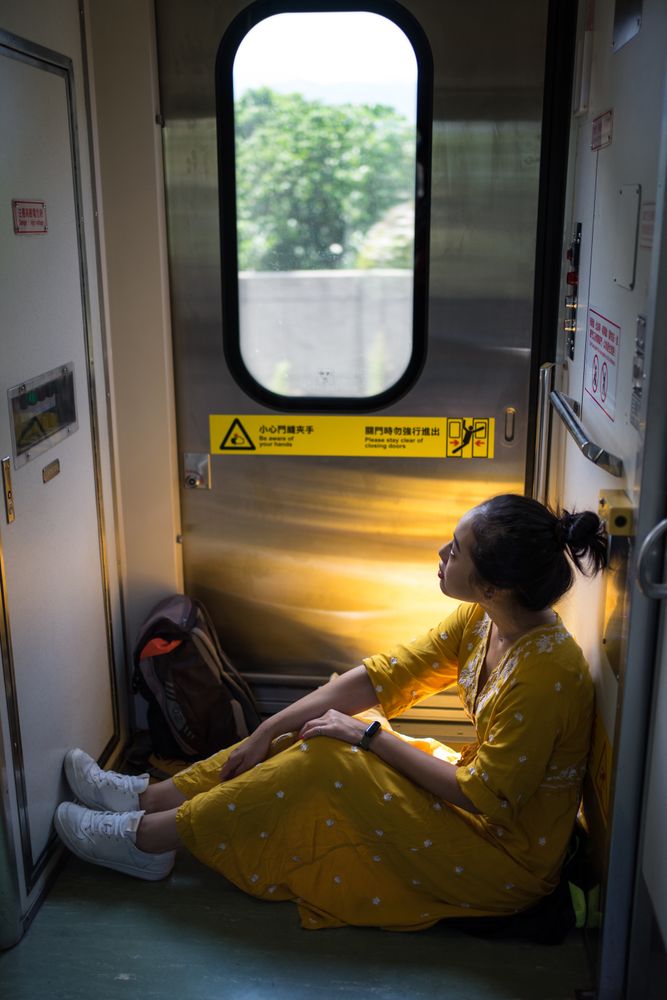 Cheerful female traveler in stylish dress at train
