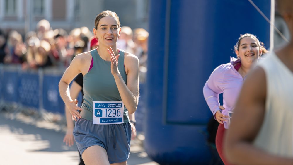 Diverse Group of People Running a Marathon in a City During the Day.