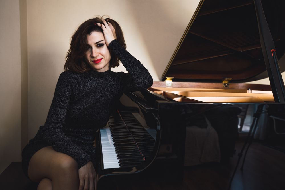 Young woman sitting at a piano posing