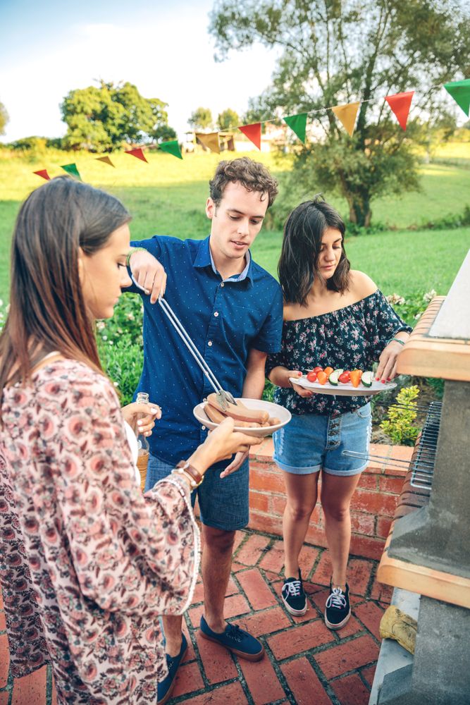 Group of friends serving meat from a summer barbecue