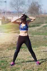Fit woman stretching before workout in park