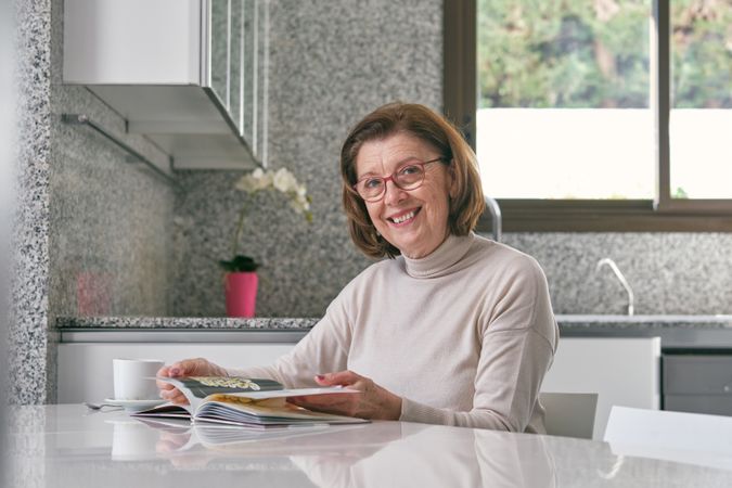 Female reading book in kitchen