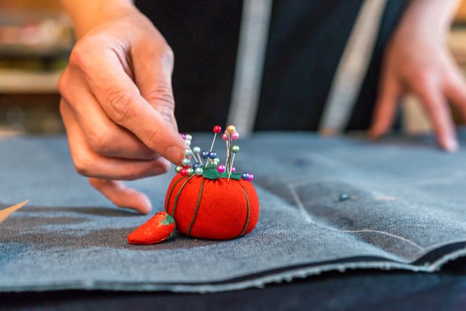 Fashion designer putting pins into a pincushion