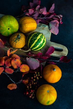 Fall squash on breadboard with leaves