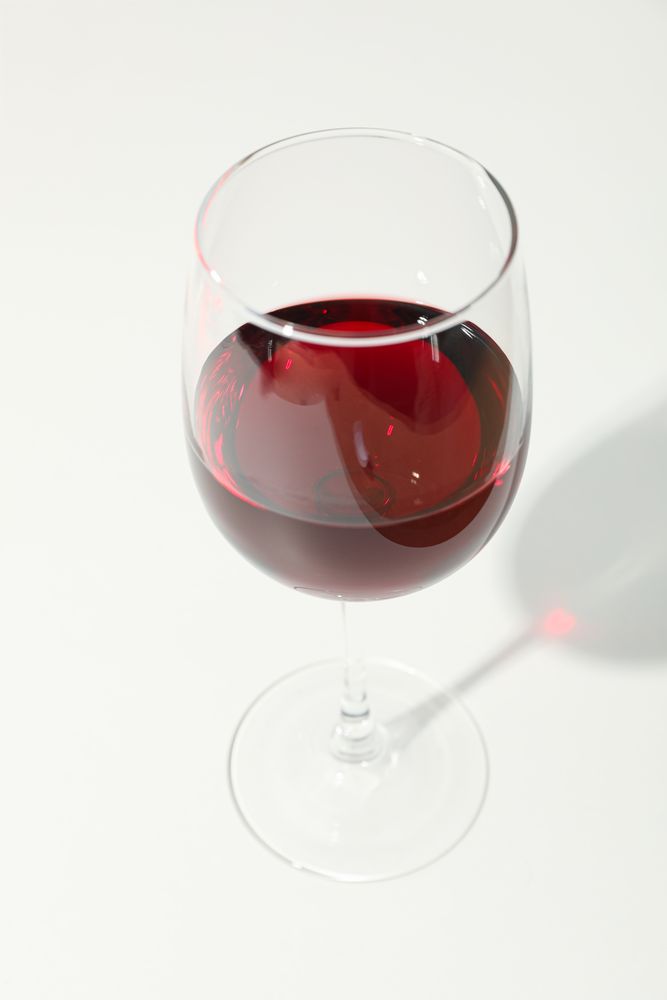 Glass with red wine on blank background, copy space