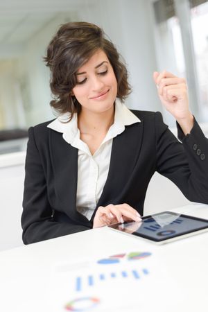 Female in business attire reviewing data and charts in a bright office