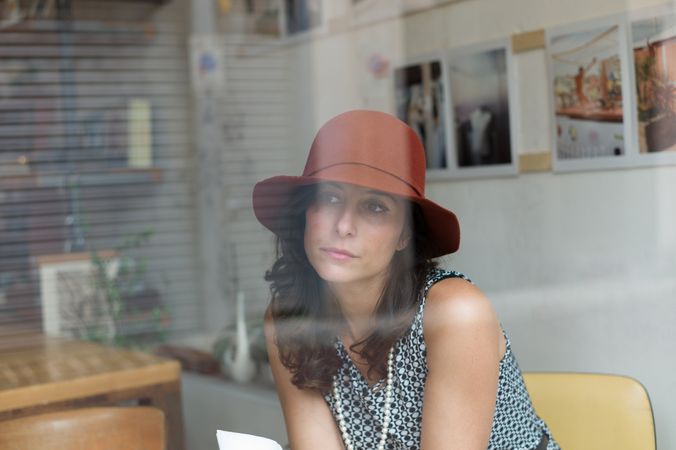 Woman wearing hat and sitting on chair indoor