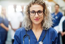 Portrait of smiling blonde woman in scrubs and stethoscope