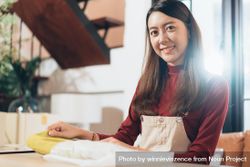 Smiling woman working with fabric at home 56exN0