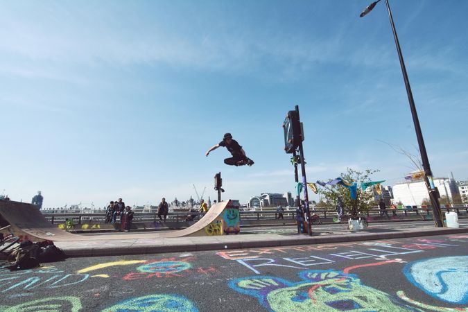 London, England, United Kingdom - April 19th, 2019: Young man skateboarding midair