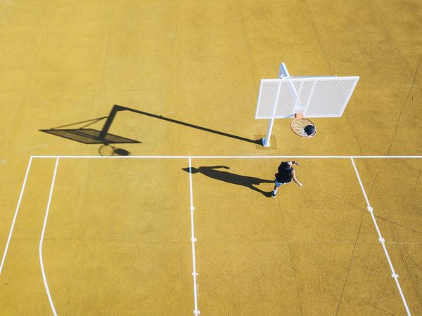 Young man playing basketball on outdoor court.