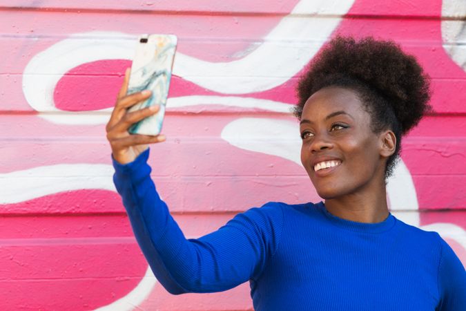Cool woman taking selfie in city