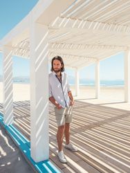 Relaxed man standing in gazebo on beach