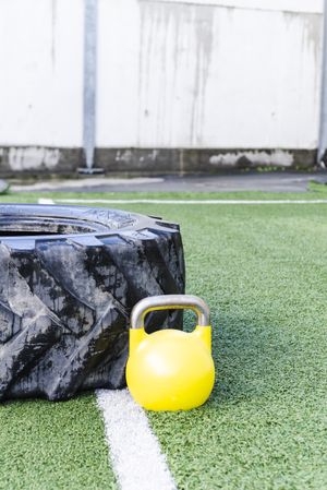 Heavy tires near kettlebell on lawn