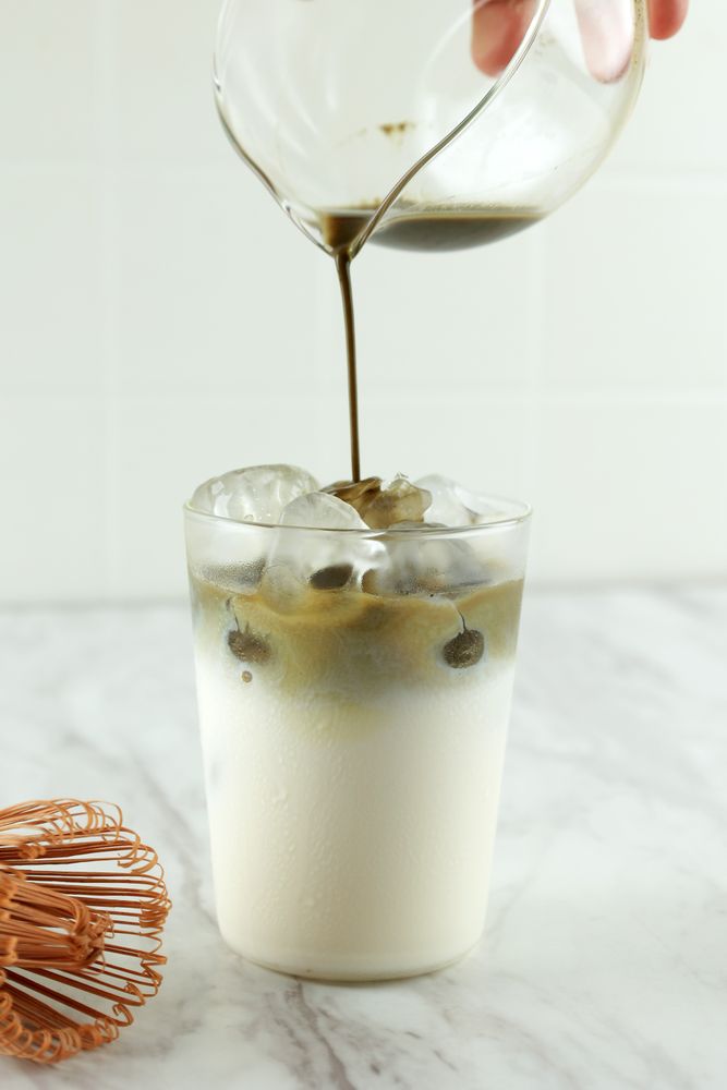 Pour Matcha Green Tea to the Milk on White Table,