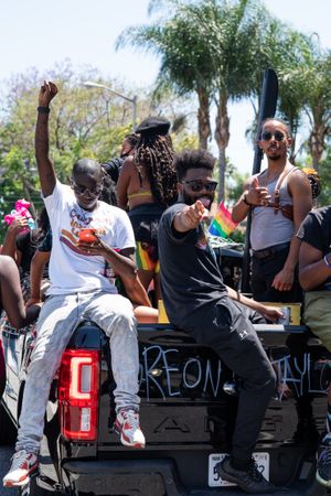 Los Angeles, CA, USA — June 14th, 2020: group of men riding in back of truck smiling at protest