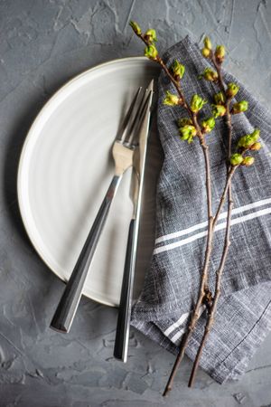 Spring table setting of plate and napkin with cherry bloom tree branches