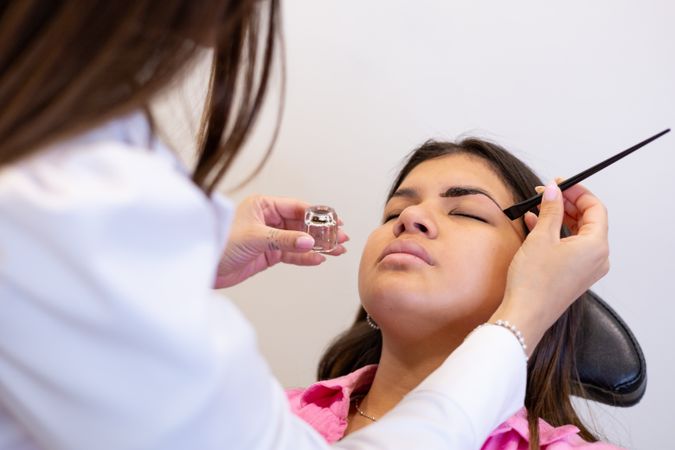 Beautician making eyebrow design and shading procedures