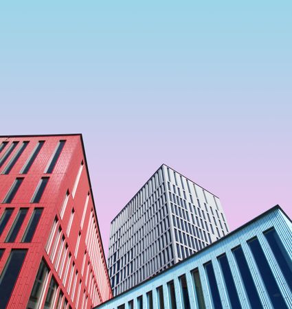 Three imposing buildings against a gradient blue pink sky