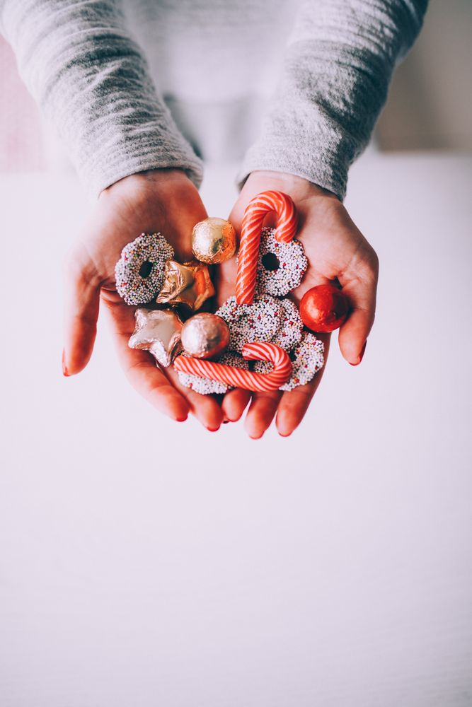 Woman holding festive cookies and candy cane treats