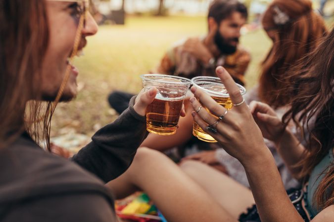 Couple toasting beers at summer festival