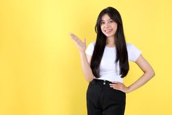 Portrait Asian Beautiful Young Woman in White Shirt Smiling Standing Pointing and Hand on Hips