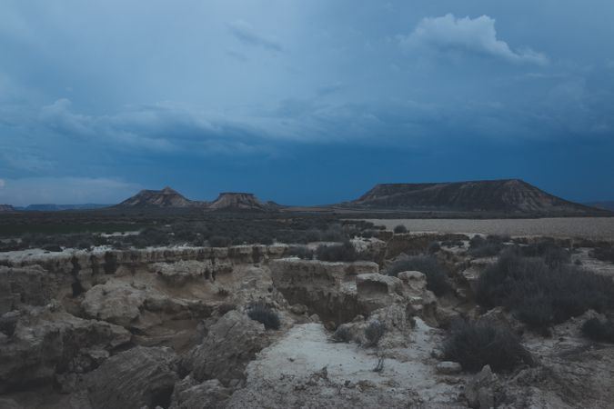 Man standing on stone in desert hills
