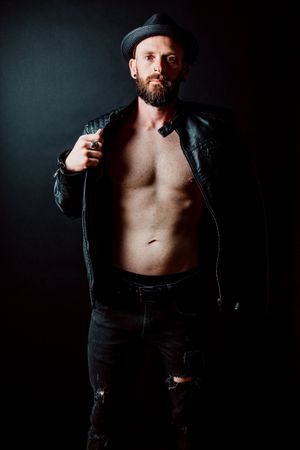 Young shirtless bearded guy in leather jacket