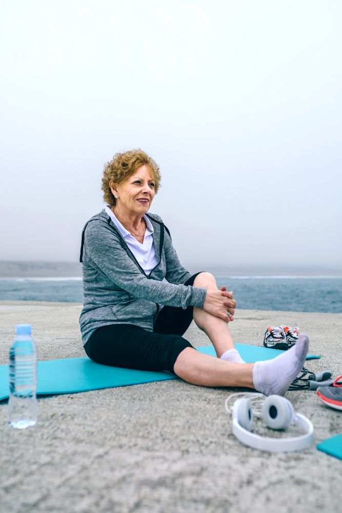 Mature sportswoman relaxing on yoga mat