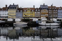 Boats lining river in Denmark with colorful homes 5QDvX0