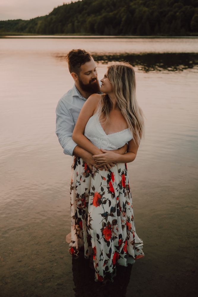 Loving couple hugging while standing ankle deep in water on beach
