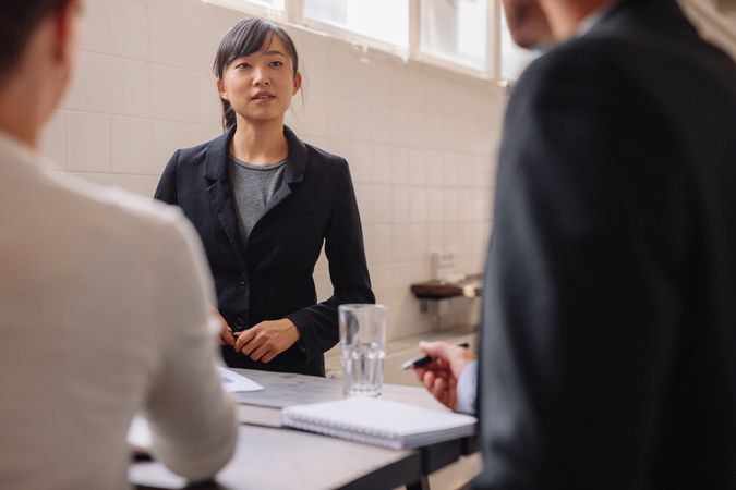 Young Asian businesswoman interacting with colleagues during business presentation