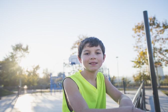 Portrait of a young teen wearing a yellow basketball sleeveless shirt smiling