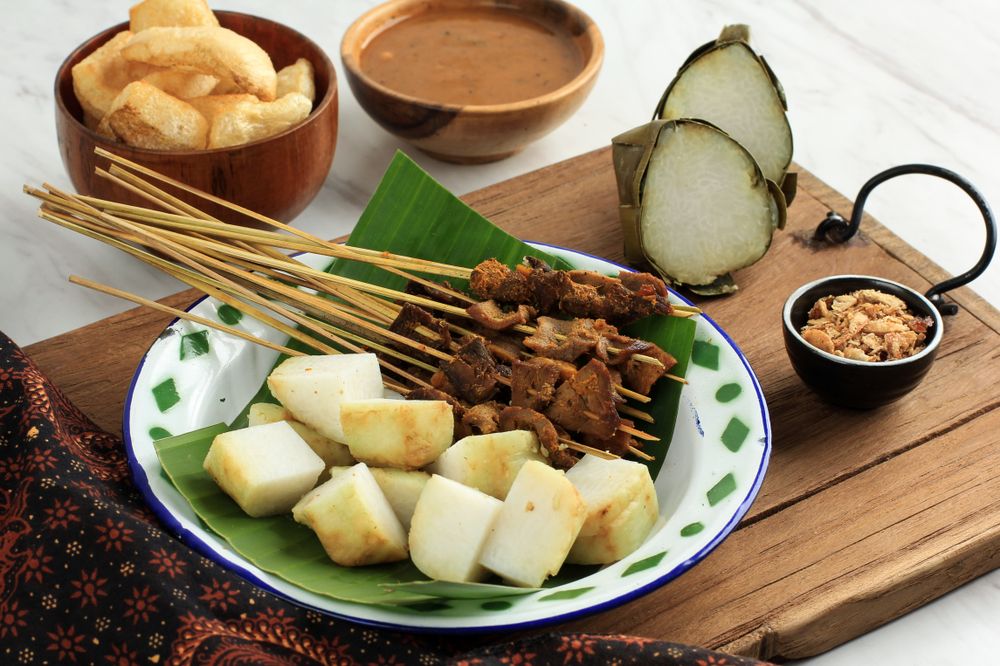 Plate of beef sate skewers served with spicy peanut sauce and sides
