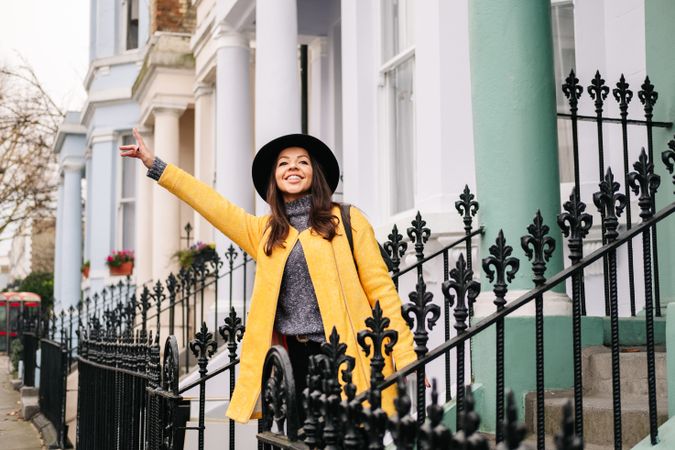 Cheerful woman hailing cab on street