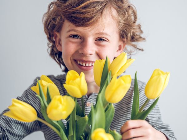 Cheerful boy with bunch of tulips