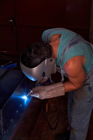 Unrecognizable workman making welding seams