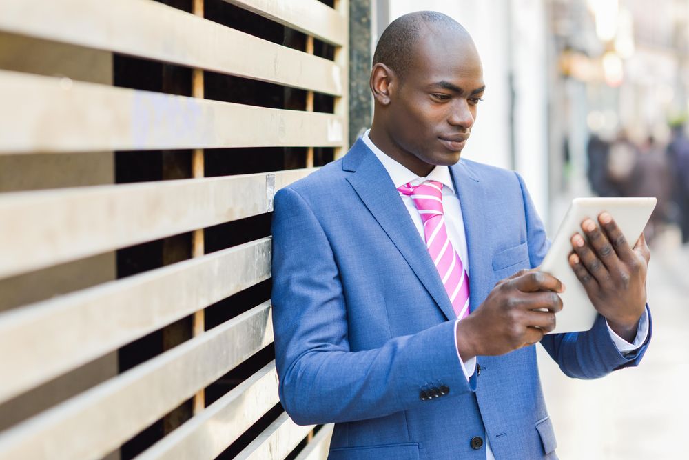 Male standing with a digital tablet on street