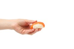 Female hand holds sushi roll, isolated on plain background