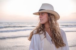 Charming woman in light white dress on wavy beach