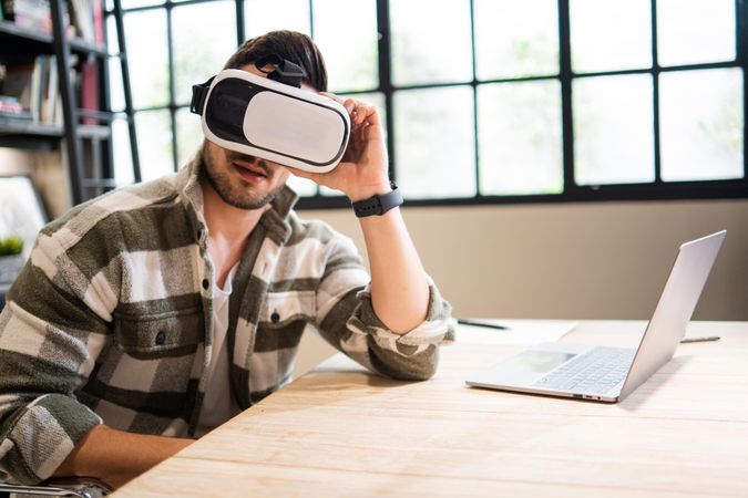 Man in bright modern office in VR headset