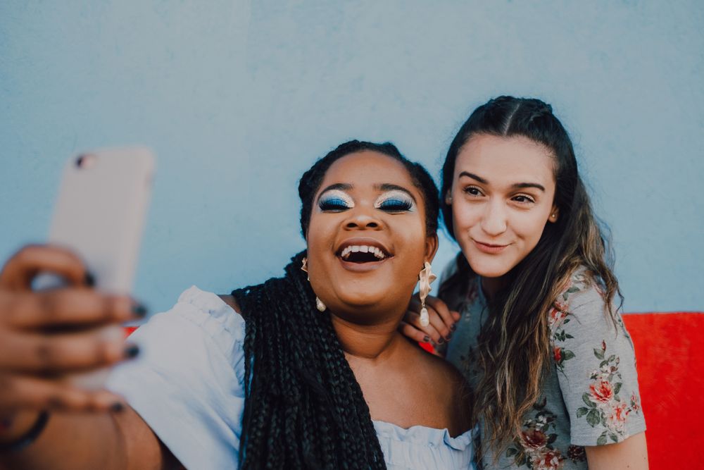 Smiling multiethnic women taking selfie