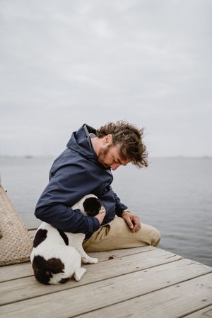 Man and dog resting on pier together