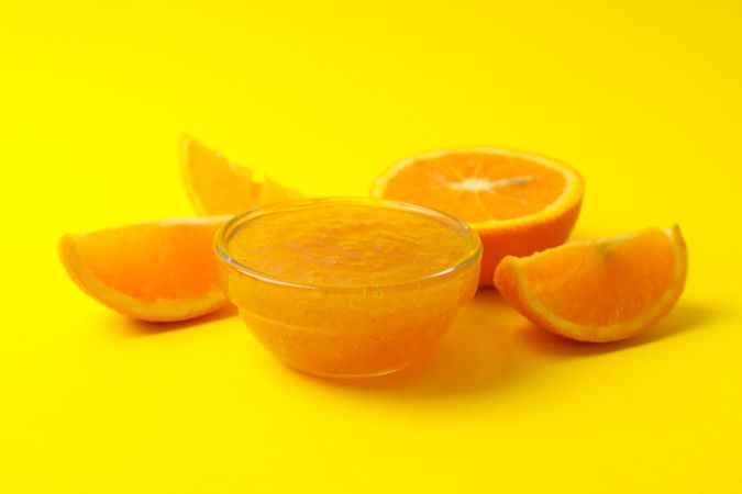 Delicious orange jam on yellow background, close up